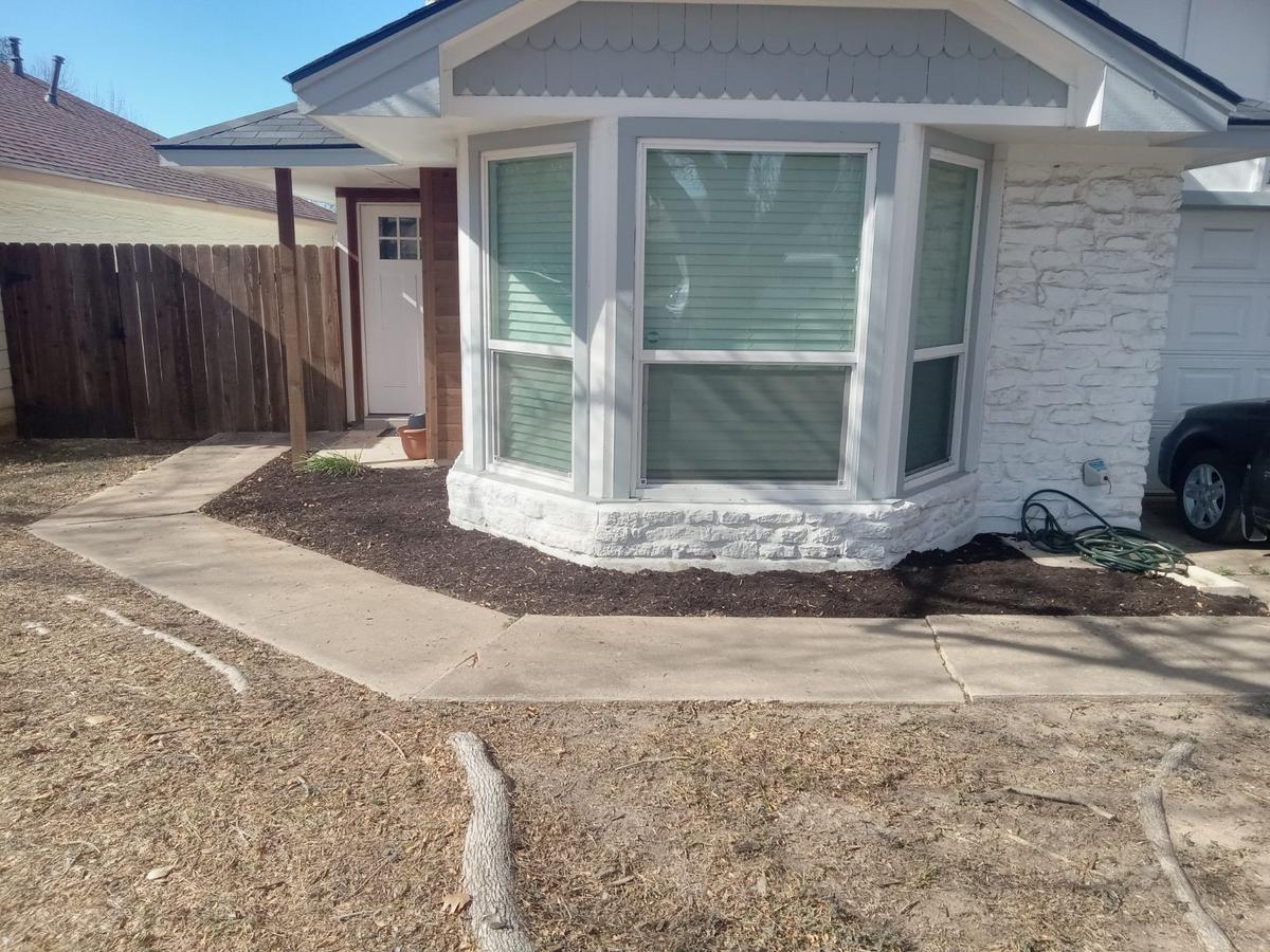 Same flower bed cleared and freshly mulched after cleanup